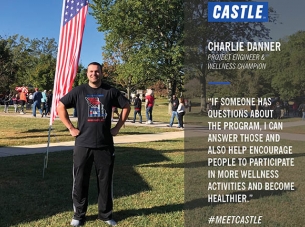 charlie danner stands in front of an American flag in a park full of people