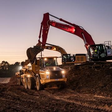 Excavator loading dirt into dump truck