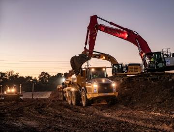 Excavator loading dirt into dump truck