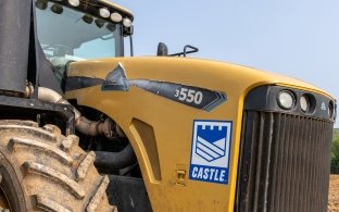 Yellow construction tractor with Castle Contracting logo on construction site