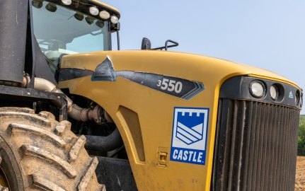 Yellow construction tractor with Castle Contracting logo on construction site